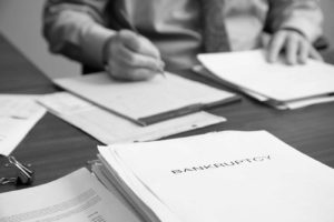 Black and white image of David R. Hillier working on bankruptcy paperwork.