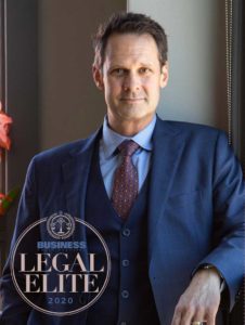 Patrick McCroskey in his office in Asheville with the 2020 Legal Elite Logo in the bottom left corner.