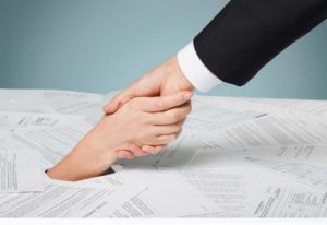 Image depicting drowning in paperwork, scattered forms with one person pulling another out from under it