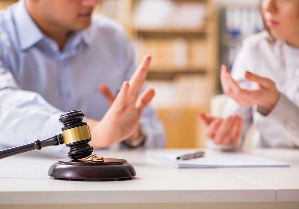 I Don't Agree Image of two people sitting at a desk cropped so that faces are implied. The gavel in the foreground denotes a legal proceeding and the hand gestures of the subjects implies that one spouse disagrees.