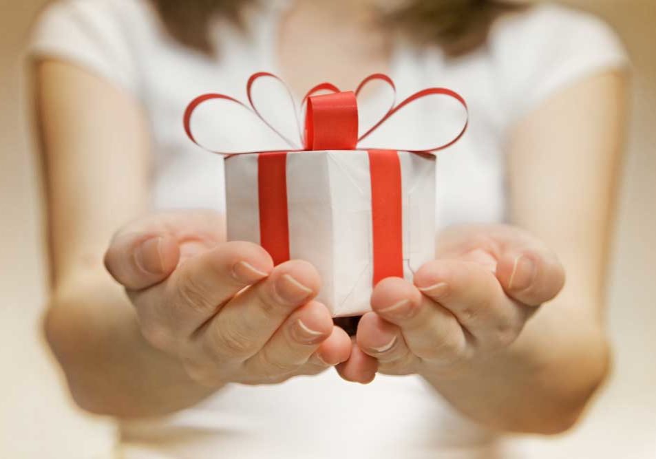 Separate Property: Gifts Image of a woman with her hands held together in front of her holding a small white package with a red bow.