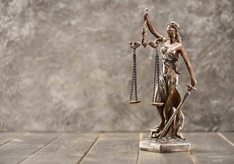Justice Small statue of Lady Justice against marble.