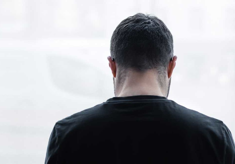 Lonely man Image of man alone in front of a window emoting sadness