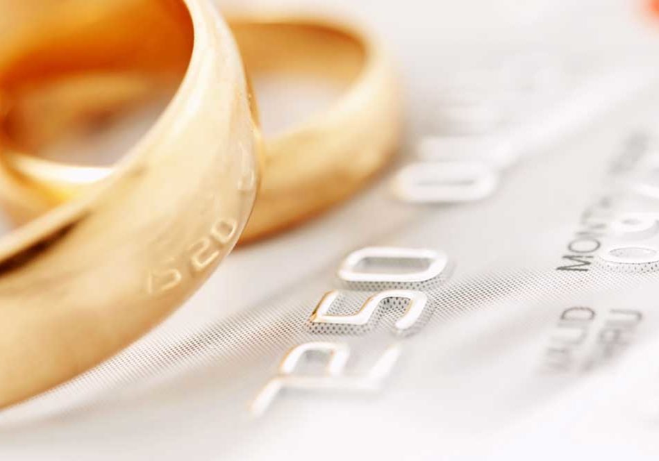 Marital Debt Closeup image of a credit card with wedding rings on the top of it depicting marital debt.