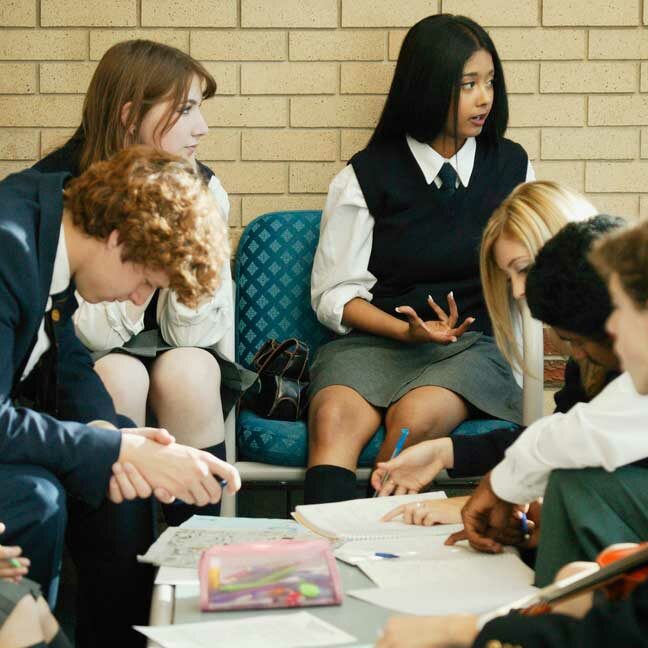 Image of a group of private school students wearing school uniforms in a study session.
