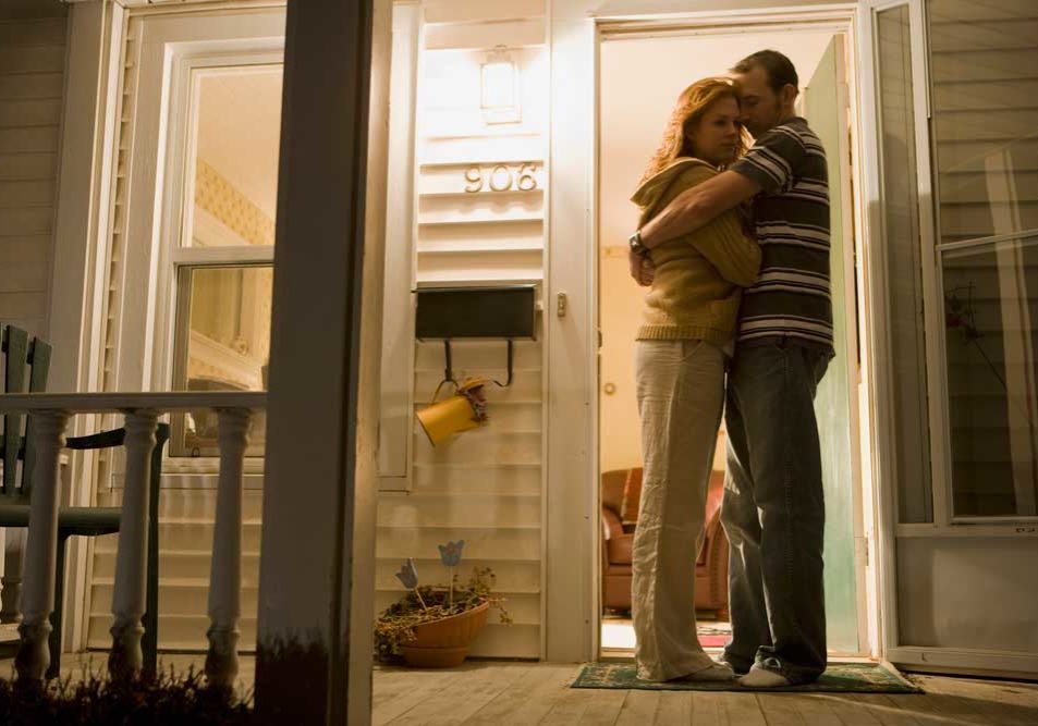 Reconciliation Couple embracing on a front porch depicting reconciliation during divorce.