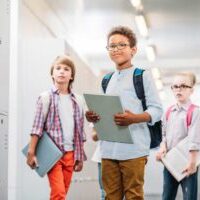 Image depicting children in a brightly lit school corridor.