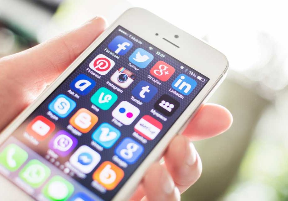 Social Media Image of lady holding mobile device covered with social media app icons