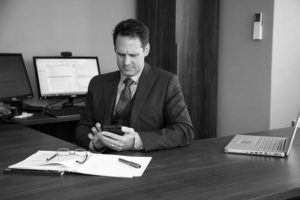 Black and white image of Patrick McCroskey at his desk working. Custom stock photography.