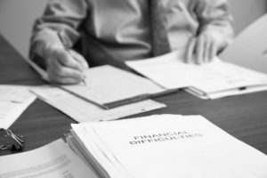 Image of Dave Hillier working at his desk with a stack of files