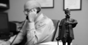 Dave Hillier in his office on the phone with statue in foreground