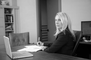 Black and white image of attorney Janet Amburgey working at her desk.