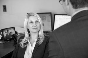 Image of Janet Amburgey and Patrick McCroskey discussing a case. Janet is the focus of the image taken from over Patrick's left shoulder.