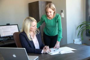 Image of Janet Amburgy and her paralegal Tracy Laws discussing documents.