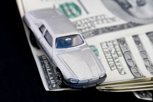 Image of matchbox car sitting on top of cash representing cash loans from family or other private agreement