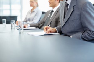 This is a stock photography image of business people at a conference table