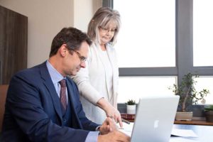 Image of Patrick McCroskeyand And his paralegal Libby Smith discussing documents.