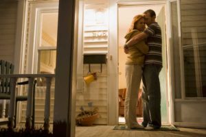 Couple embracing on a front porch depicting reconciliation during divorce.